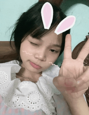a girl with bunny ears on her head gives the peace sign