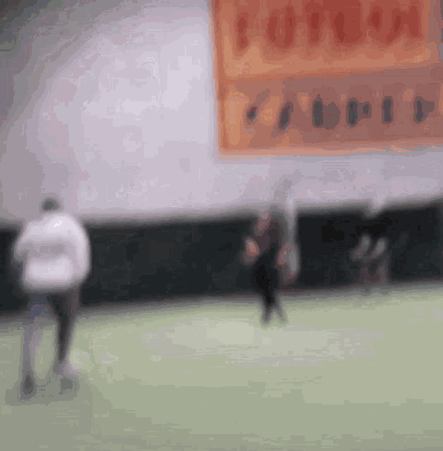 a blurry picture of people playing soccer in front of a sign that says ' forum ' on it