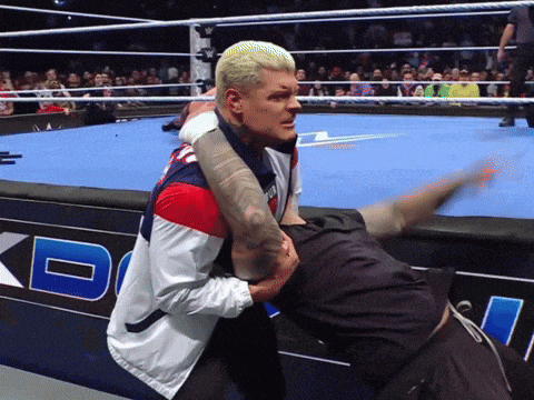 a man in a red white and blue jacket is wrestling another man on a blue mat