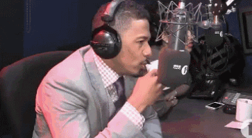 a man in a suit and tie is wearing headphones in front of a microphone that has the number 0 on it
