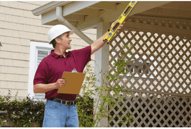 a man wearing a hard hat is holding a level that says ' stanley ' on it