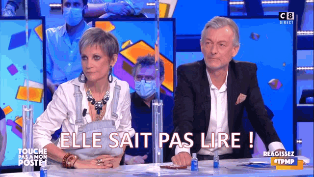 a man and a woman sitting at a table with the words elle sait pas lire