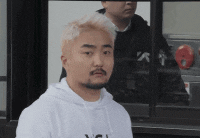a man with blonde hair and a beard is wearing a white hoodie with the letter n on it
