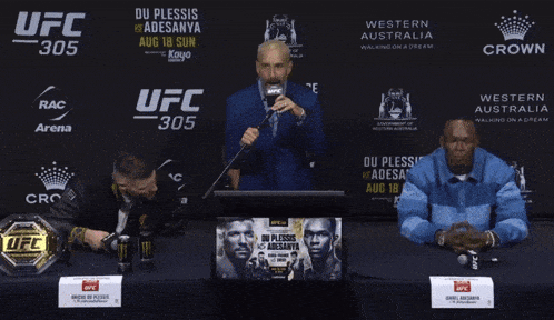 a man speaking into a microphone in front of a ufc 305 banner