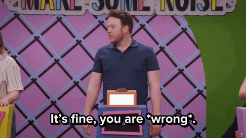 a man in a blue shirt stands in front of a sign that says it 's fine you are wrong