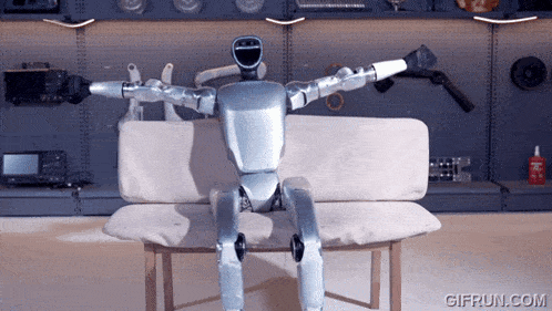 a robot is sitting on a couch with a gifrun.com logo in the corner