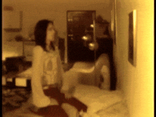 a blurred image of a woman sitting on a bed