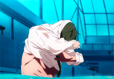 a man with green hair and a white shirt is kneeling in the water