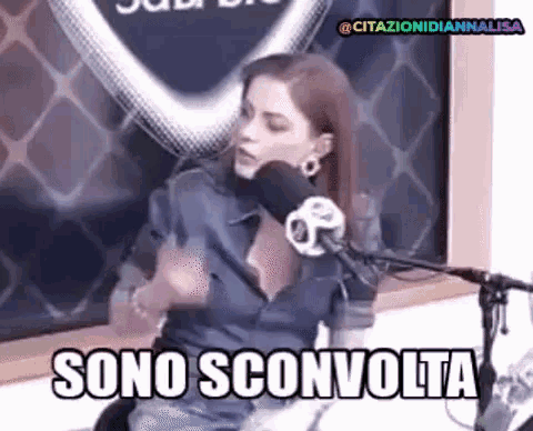 a woman is sitting in front of a microphone with the words sono sconvolta in front of her .