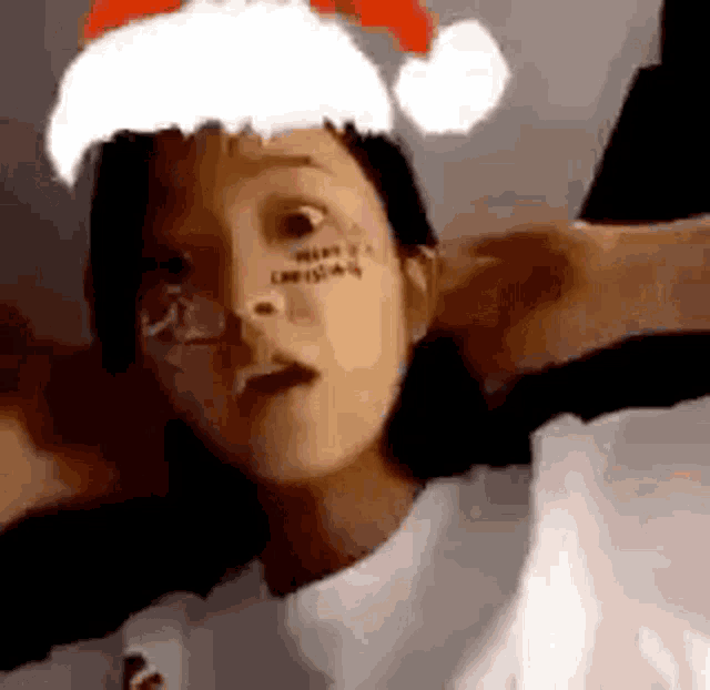 a woman is wearing a santa hat and glasses .