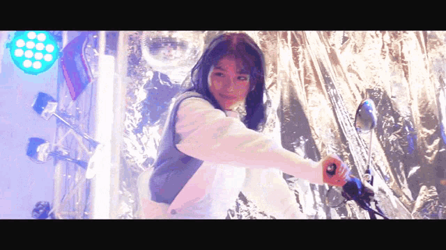 a woman is holding a motorcycle handlebars in front of a disco ball