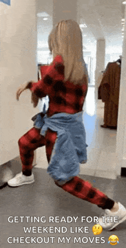 a woman is getting ready for the weekend like checkout my moves in a clothing store .