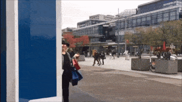 a woman stands in front of a building that says ' rotterdam of ' on it