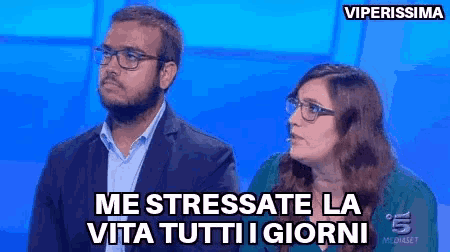 a man and a woman are sitting in front of a blue background with the words " me stressate la vita tutti i giorni "