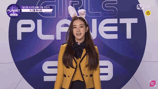 a girl wearing bunny ears is standing in front of a sign that says planet 999