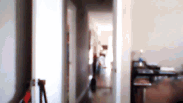 a blurry picture of a hallway leading to a room