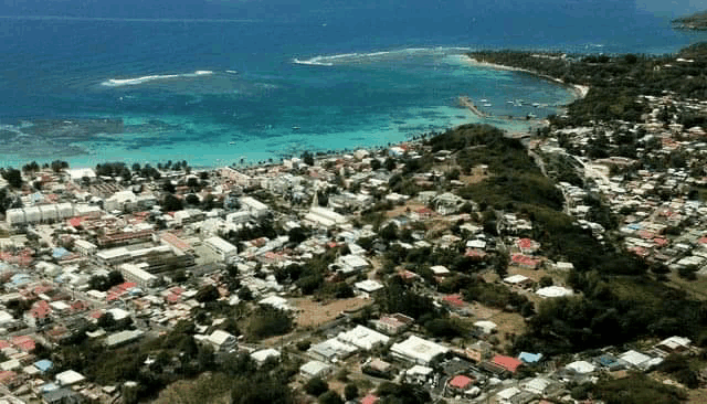 an aerial view of a small town on a hill overlooking the ocean