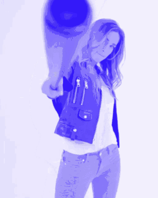 a woman in a blue leather jacket is holding a bat