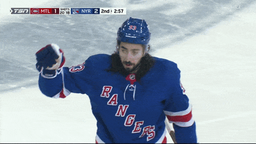 a hockey player wearing a rangers jersey celebrates a goal