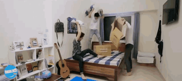 a group of young men are having a pillow fight in a room with a sign that says " saigon " on it