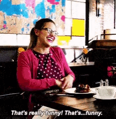 a woman is sitting at a table with a plate of food and says that 's really funny that 's funny