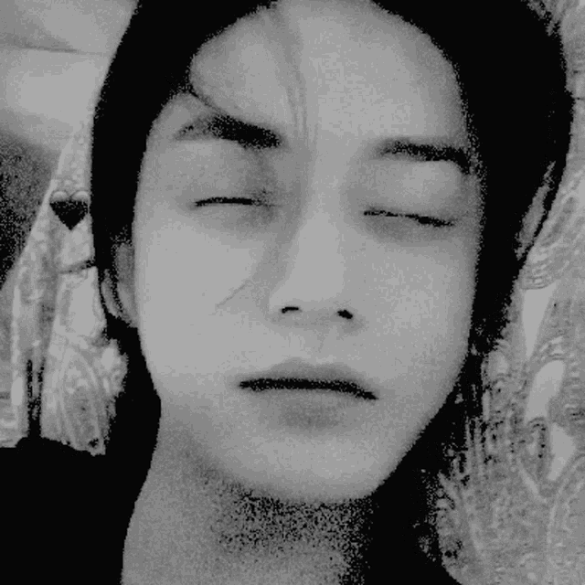 a woman 's face is shown in a black and white photo with her eyes closed