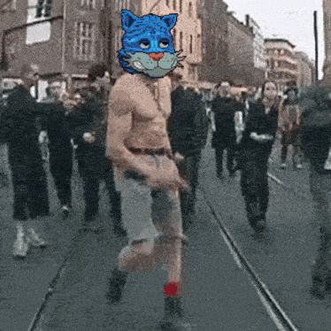 a shirtless man with a blue cat mask on his head walking down a street