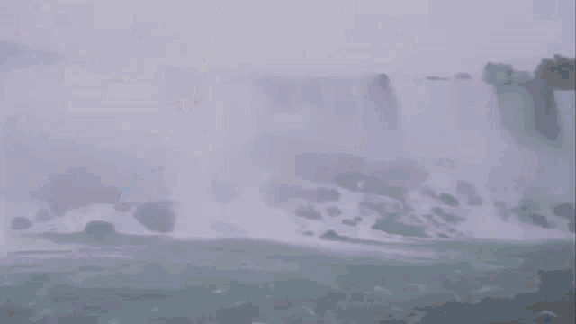 a man is wearing a blue raincoat and crying while riding a boat .