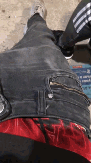 a person wearing a pair of black jeans with a zipper on the back