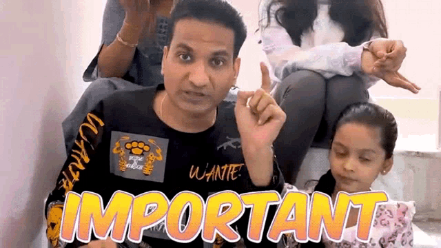 a group of people are sitting around a man wearing a shirt that says important on it