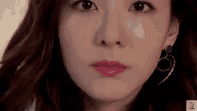 a close up of a woman 's face with a pink lipstick on her lips .