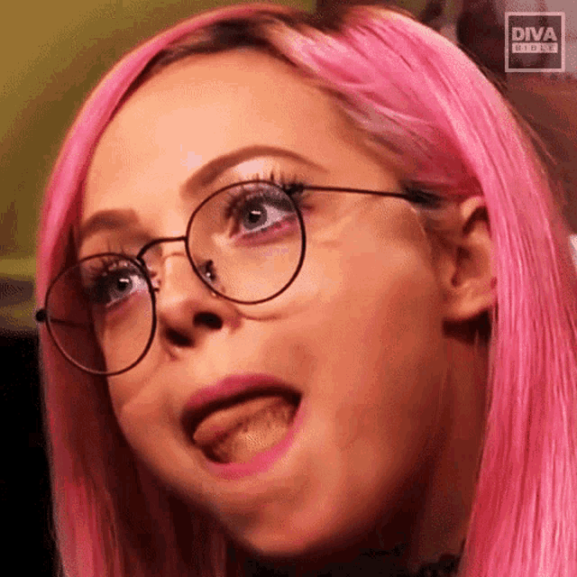a woman with pink hair is wearing glasses and making a funny face with the diva logo in the background