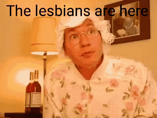 a man wearing glasses and a hat with the words the lesbians are here behind him