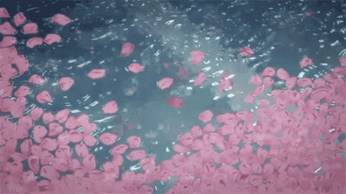 a bunch of pink petals are falling into a body of water .