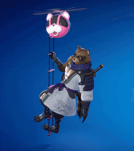 a raccoon is hanging from a rope with a pink teddy bear on it