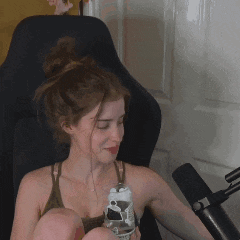 a woman is sitting in a chair holding a glass and a bottle .