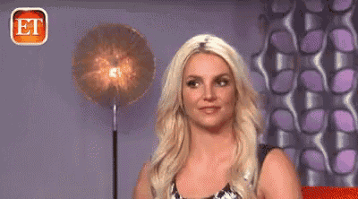 a woman with blonde hair is making a funny face in front of a lamp .
