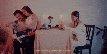 a man and woman are sitting at a table with the words nos casamos y viajamos por el mundo