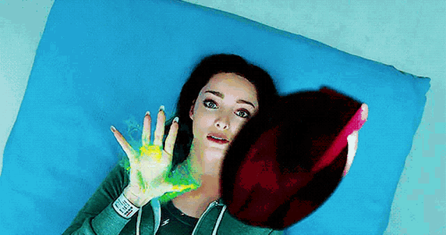 a woman is laying on a bed with her hand covered in green liquid