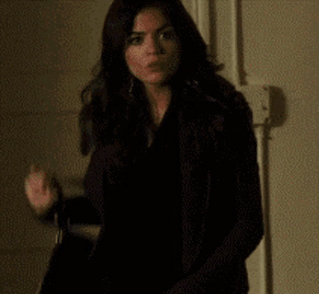 a woman in a black coat is standing in a doorway
