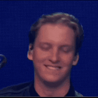 a man is smiling with his eyes closed and his mouth open .