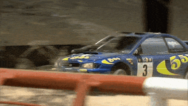 a blue and yellow race car with the number 3 on it