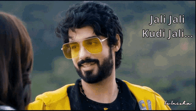 a man with a beard wearing yellow sunglasses and a yellow jacket