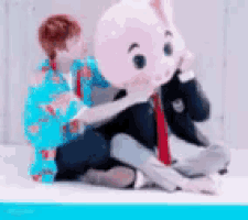 a person in a blue shirt is sitting next to a stuffed animal