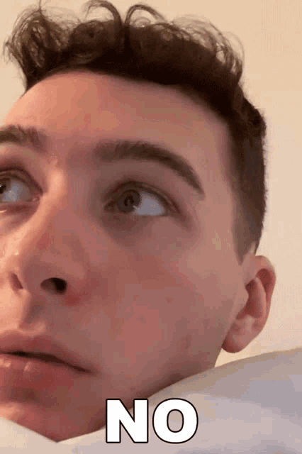 a close up of a man 's face with the word no written in white