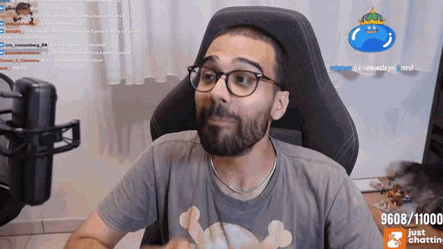 a man with glasses and a beard is sitting in front of a screen that says 9608/11100 just chatting