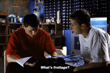 two boys are sitting on a bed and one of them is wearing a red shirt that says " what 's frotage "