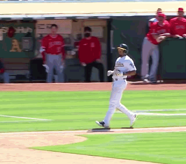 a baseball player for the oakland athletics walks towards the dugout