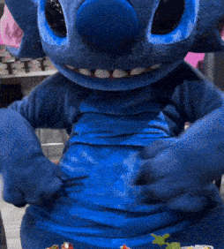 a blue stuffed animal with a big belly is sitting on a table