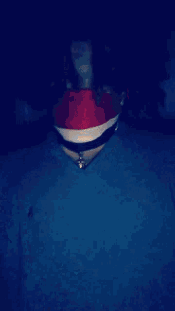 a blurry picture of a person wearing a red hat and a silver necklace .